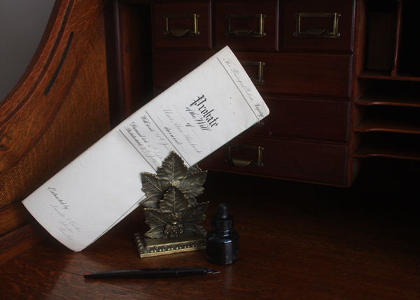 A vintage ink pen and inkwell beside an ornamental paperweight on a wooden desk with a partially unfolded letter featuring elegant handwriting and decorative elements, relevant for 6 classic writing tools.