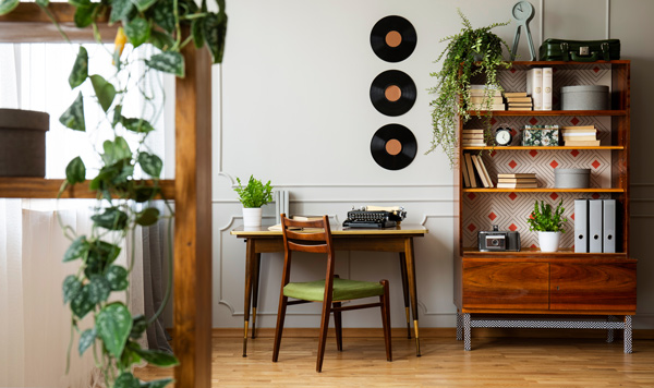 home office with vintage typewriter green chair and bookshelf with plants and records